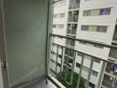 Small balcony with air conditioning unit and view of adjacent buildings