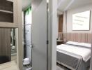 Modern bedroom interior with mirrored wardrobe and en-suite bathroom