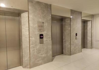 Marble-clad elevator lobby with three elevators