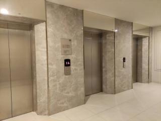 Marble-clad elevator lobby with three elevators