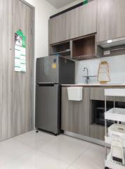 Modern kitchen with stainless steel refrigerator and wooden cabinets