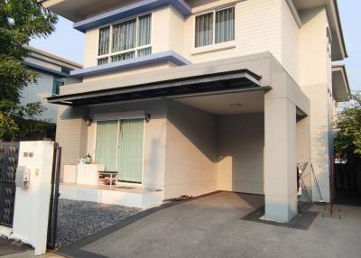 Modern two-story house with spacious carport and white facade