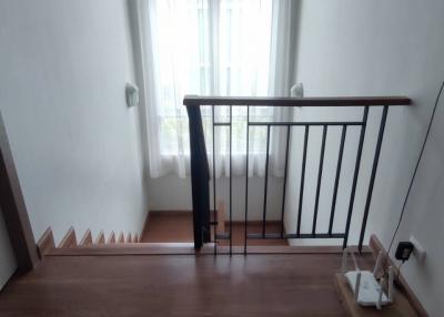 Spacious and well-lit staircase area leading to the lower floor with wooden flooring