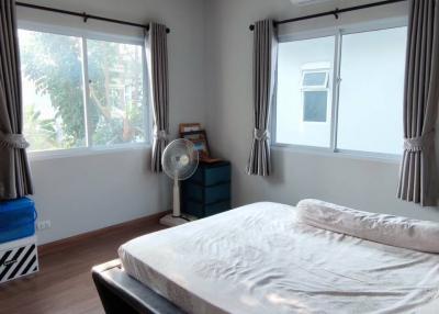 Spacious and well-lit bedroom with large windows and a comfortable bed