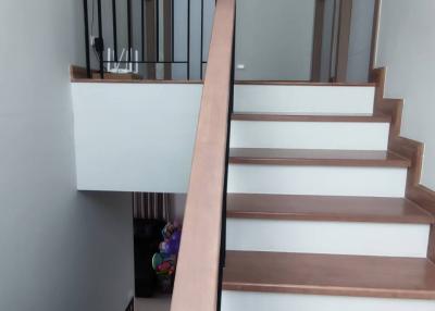 Modern staircase with wooden steps and metal balustrade in a residence