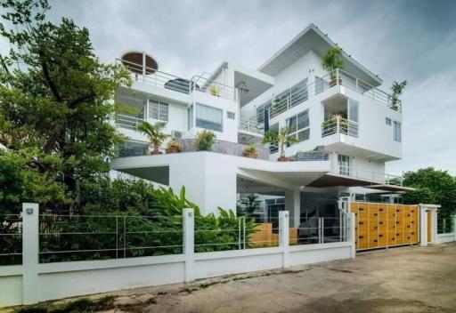 Modern multi-story residential building with balconies and greenery