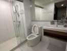 Modern bathroom with glass shower enclosure, toilet, and sink