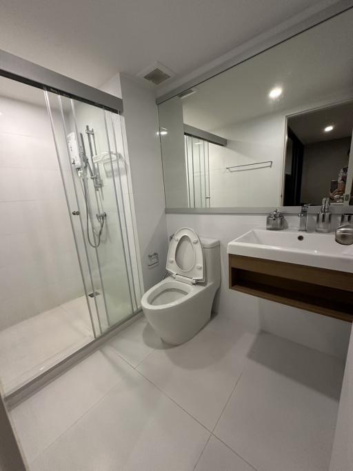 Modern bathroom with glass shower enclosure, toilet, and sink