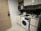 Modern compact kitchen with built-in appliances and white cabinetry