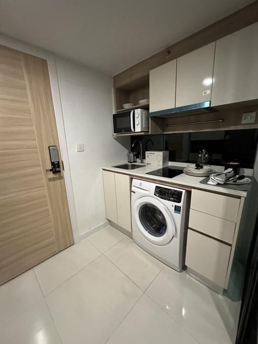 Modern compact kitchen with built-in appliances and white cabinetry