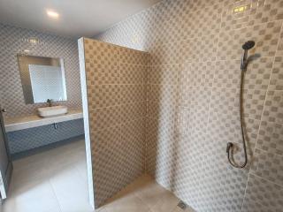 Modern tiled bathroom with walk-in shower and wall-mounted sink