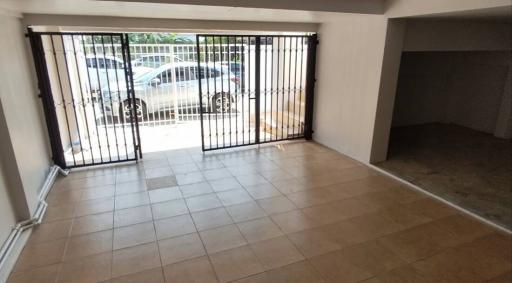 Spacious building interior with secured gate and tiled flooring