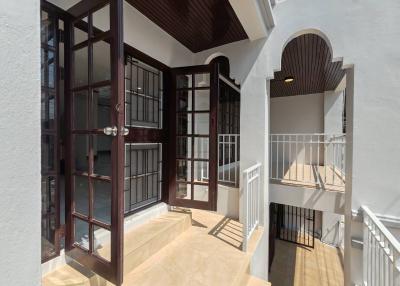 Bright and spacious balcony with large windows and door entry