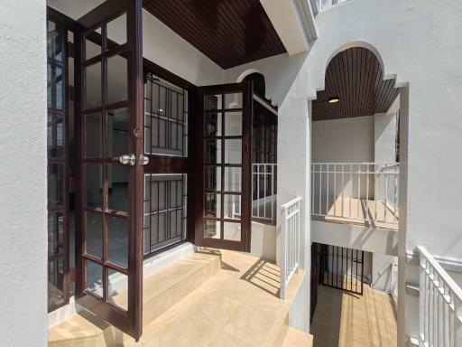 Bright and spacious balcony with large windows and door entry