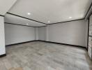 Spacious empty living room with tiled flooring and bright recessed lighting