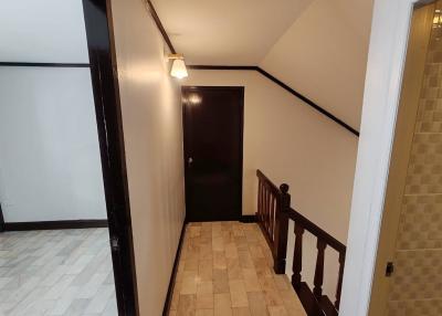 Spacious hallway with tiled flooring and wooden railing
