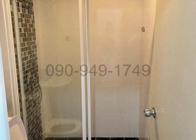 Compact modern bathroom with glass shower and dark tiled floor