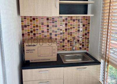 Compact modern kitchen with wooden cabinets and mosaic backsplash