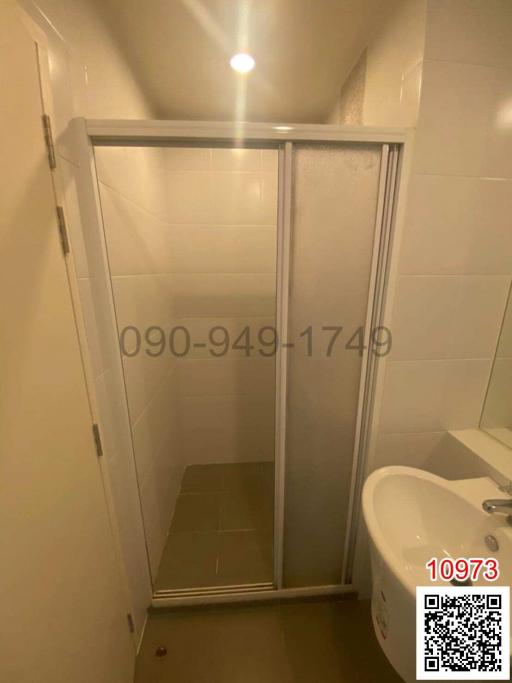Compact bathroom with enclosed shower and toilet