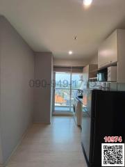 Modern compact kitchen leading to a well-lit balcony