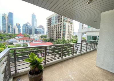 Spacious balcony with a view of city skyline and a potted plant