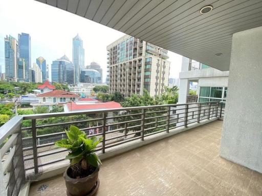 Spacious balcony with a view of city skyline and a potted plant