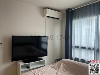 Modern bedroom with large window and mounted television