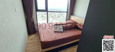 Compact bedroom with a large window view and a laptop on the bed