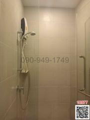 Modern bathroom interior with wall-mounted shower and safety handrails