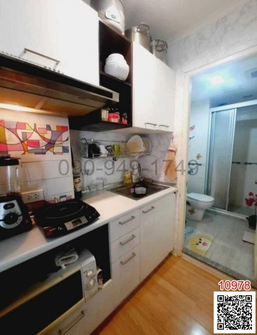 Compact fully-equipped kitchen with modern appliances and white cabinets
