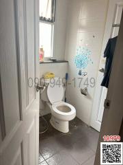 Small white tiled bathroom with natural light from window