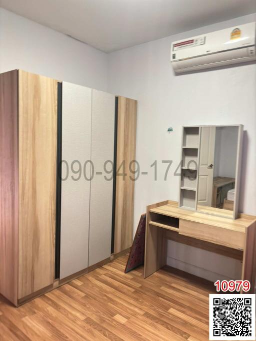 Compact bedroom with wooden wardrobe and air conditioning unit