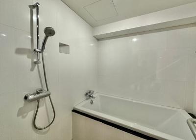 Modern white tiled bathroom with bathtub and shower