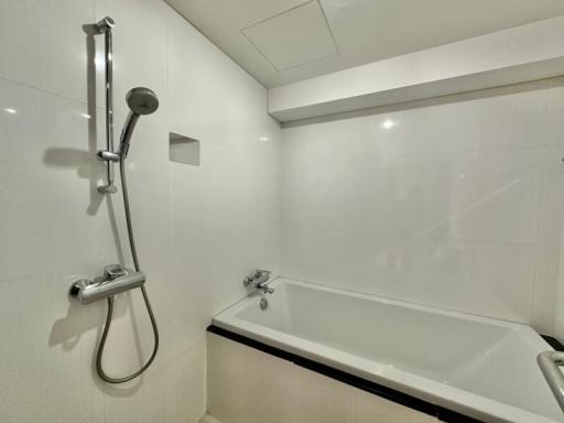 Modern white tiled bathroom with bathtub and shower