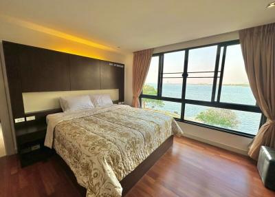 Spacious bedroom with a large bed and waterfront view