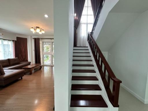 Spacious living area with staircase and natural lighting