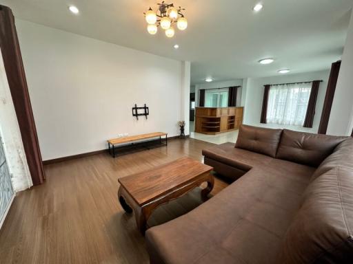 Spacious and modern living room with large sofa and hardwood flooring