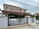 Suburban two-story house with a carport and gated entry