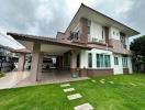 Spacious two-storey house with carport and green lawn