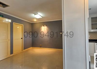 Spacious unfurnished apartment interior with open floor plan showing entrance and kitchen area