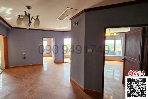 Spacious interior view of a vacant building with tiled flooring and multiple doorways