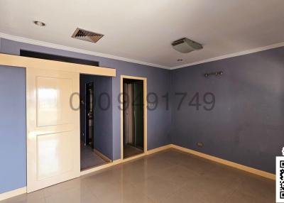 Spacious bedroom with blue walls and tiled flooring