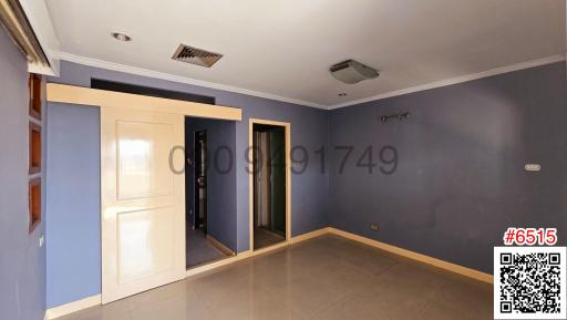 Spacious bedroom with blue walls and tiled flooring