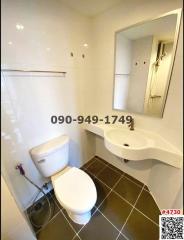 Compact modern bathroom with white fixtures and dark floor tiles