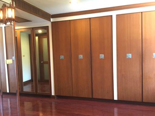 Spacious hallway with wooden wardrobes and tiled flooring