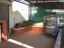 Outdoor patio area with brick barbecue pit and storage tank