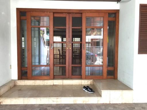 Elegant wooden double door entrance of a residential property with tiled steps