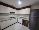 Modern kitchen with white cabinets and stainless steel appliances