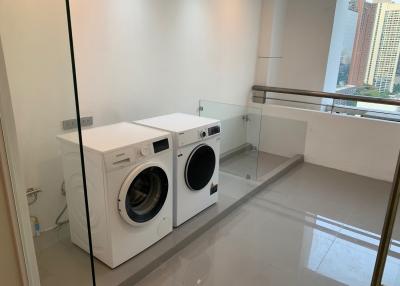 Modern laundry room with washing machine and dryer in a high-rise apartment