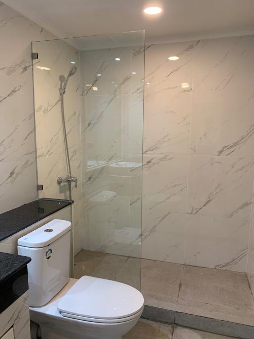 Modern bathroom interior with marble tiles and glass shower